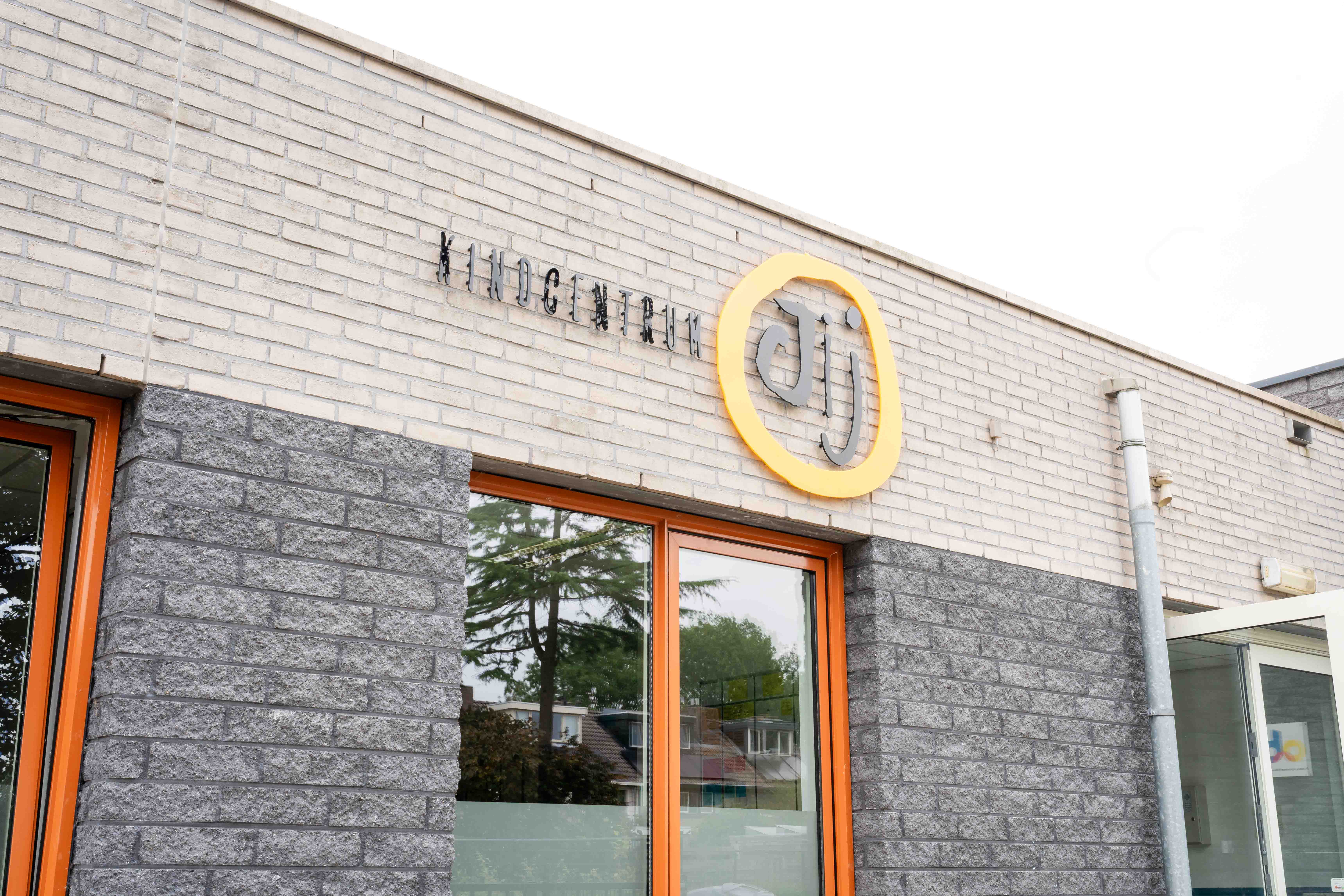 Het schoolgebouw van Kindcentrum Jij met het aangrenzende schoolplein in Terheijden.